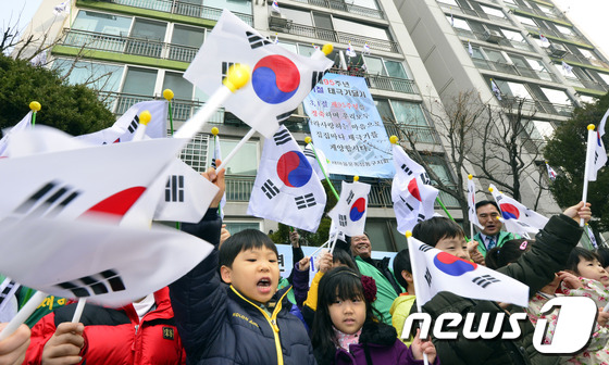 (서울=뉴스1) 최영호 기자 = 제95주년 3.1절을 앞두고 25일 오전 서울 성동구 사근동 중앙하이츠아파트에서 주민들과 아이들이 태극기를 흔들고 있다.성동구는 순국선열의 숭고한 …