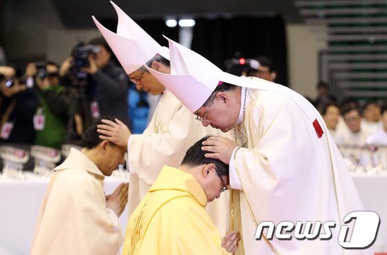 본문 이미지 - 5일 오후 서울 송파구 방이동 올림픽공원 체조경기장에서 열린 천주교 서울대교구 유경촌(세례명 티모테오·51)주교와 정순택(베드로·52)주교에 대한 주교서품식에서 조규만 주교를 비롯한 주교단이 안수하고 있다. . 2014.2.5/뉴스1 © News1   한재호 기자