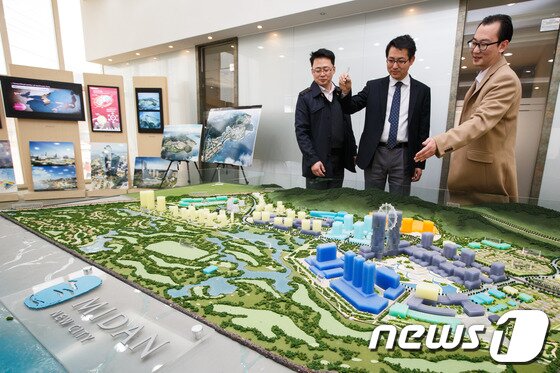 본문 이미지 - 미단시티개발 직원들이 미단시티홍보관에서 카지노 복합리조트 모형을 가리키며 설명하고 있다. /뉴스1 ⓒ News1