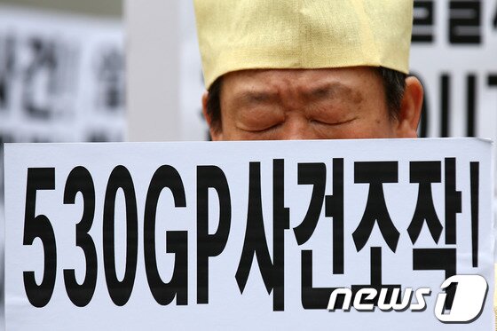 본문 이미지 - 19일 오후 서울 광화문광장에서 열린 '연천530GP 총기난사 사건' 진상규명 촉구 기자회견에서 한 희생자 유가족이 '사건 조작'을 주장하는 손팻말을 들고 있다. © News1 한재호 기자