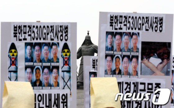 (서울=뉴스1) 한재호 기자 = 19일 오후 서울 광화문광장에서 열린 '연천 530GP 총기난사 사건' 진상규명 촉구 기자회견에서 참석자들이 희생자들의 사진이 담긴 팻말을 들고 있 …