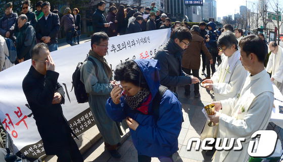 (서울=뉴스1) 양동욱 기자 = 5일 서울 광화문 파이낸스빌딩 앞에서 열린 송파 세 모녀 자살 사건 추모의식에서 정의평화위원회 등 참석자들이 추모기도를 올리고 있다.세 모녀 자살사 …