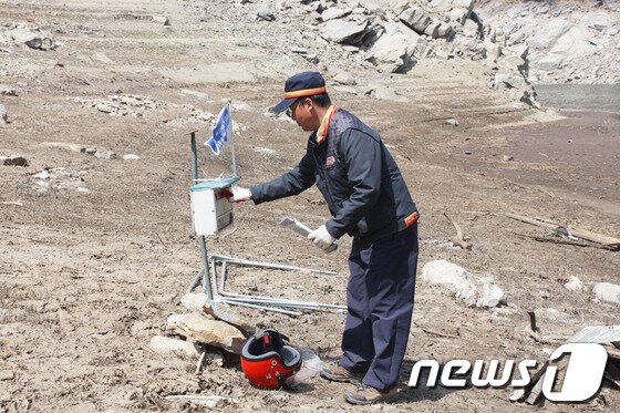본문 이미지 - 김영권 집배원은 육로로 갈 수 없는 지역에 사는 마을 주민을 위해 소양호 조교리 선착장에 설치된 보관부교지에 우편물을 넣어 놓는다.&#40;사진제공=강원지방우정청&#41;.2014.4.25/뉴스1 © News1 권혜민 기자  
