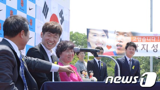 본문 이미지 - 은퇴를 선언한 박지성&#40;오른쪽&#41;이 14일 오전 경기도 수원시 영통구 박지성축구센터에서 열린 은퇴기자회견에서 깜짝 방문한 예비신부 김민지&#40;전 아나운서&#41;씨의 꽃다발을 받고 있다.2014.5.14/뉴스1 © News1   이동원 기자