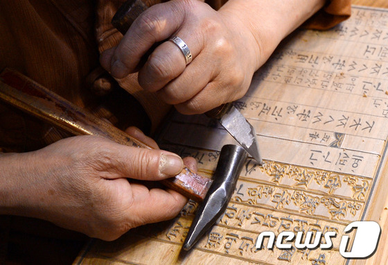 (서울=뉴스1) 이동원 기자 = 16일 서울 종로구 국립민속박물관 에서 열린 '목판 지식의 숲을 거닐다'행사에서 김각한 중요무형문화재 각자장 보유자와 전수생이 목판 각자 인출시연을 …