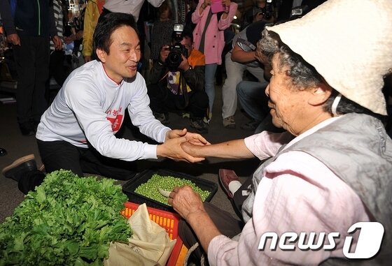 본문 이미지 - 6.4 지방선거 공식선거운동이 시작된 22일 오전 제주시 민속오일시장을 찾은한 새누리당 원희룡 제주지사 후보가 상인들과 인사하고 있다. 2014.5.22/뉴스1  © News1   이상민 기자