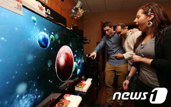 본문 이미지 - 지난 4월 말 미국 뉴욕 맨하탄 내 세계 최대 가전매장인 베스트바이를 찾은 고객들이 LG TV 부스에서 뛰어난 화질에 깜짝 놀라고 있다. 2014.6.12/뉴스1 © News1   (뉴욕(미국)=뉴스1) 허경 기자