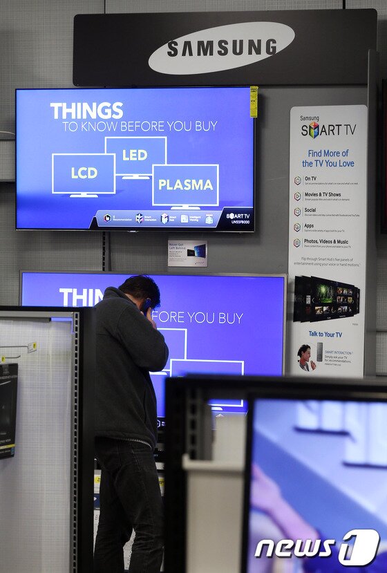 본문 이미지 - 지난 4월 말 미국 뉴욕 맨하탄 내 세계 최대 가전매장인 베스트바이를 찾은 고객들이 삼성 스마트폰 부스에서 제품을 고르고 있다.  2014.6.12/뉴스1 © News1   (뉴욕(미국)=뉴스1) 허경 기자