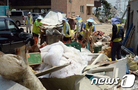 본문 이미지 - '토네이도' 피해를 입은 경기 고양시 일산서구 구산동 일원에서 11일 오후 봉사활동에 나선 농협하나로클럽 관계자들이 바람에 날아온 온실시설물을 수거하고 있다. 기상청은 10일 오후 7시께 고양시 장월나들목 인근 한강 둔치에서 토네이도 현상이 발생해 한시간 동안 지속됐다고 밝혔다. 이번 토네이도로 구산동 일원 장미 재배용 비닐하우스 등 원예시설물 20동 이상이 파손되는 피해를 입었다. 2014.6.11/뉴스1 © News1   정회성 기자