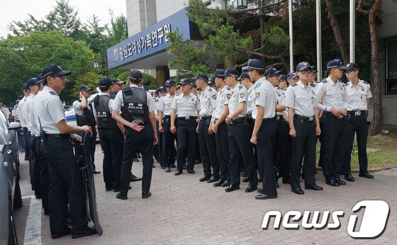 본문 이미지 - 18일 오후 2시에 농림축사식품부 주최로 강원 춘천시 강원도여성가족연구원에서 열린 쌀 관세화 유예 종료 강원권 설명회를 도내 농민단체들이 저지하자 돌발 사태를 대비하기 위해 경찰기동대들이 설명회장 밖에서 대기하고 있다. 2014.6.18/뉴스1 © News1   이예지 기자