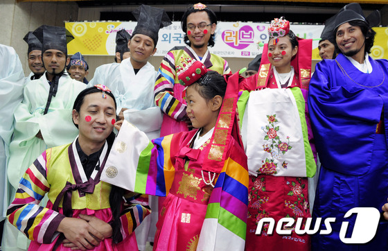 (대구=뉴스1) 정훈진 기자 = 전통혼례복장을 입은 외국인 근로자들이 22일 대구시 달서구청 대강당에서 전통혼례를 체험하며 즐거워 하고 있다.달서구청은 외국인 근로자 적응프로그램인 …