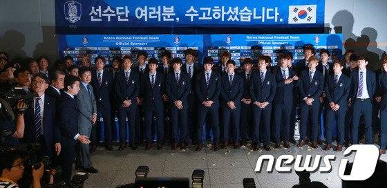 본문 이미지 - 2014 브라질 월드컵에서 H조 최하위를 기록하며 16강 진출에 실패한 축구대표팀 홍명보 감독과 선수들이 30일 오전 인천국제공항을 통해 귀국한 가운데 단체사진을 찍으려는 선수들에게 일부 팬들이 엿을 던지며 야유를 보내고 있다.한국 축구의 9번째 월드컵 도전은 16년 만의 무승이라는 최악의 성적으로 막을 내렸다. 2014.6.30/뉴스1 © News1 오대일 기자