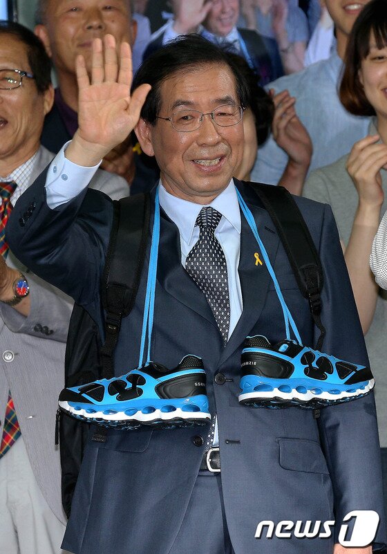 본문 이미지 - 박원순 새정치민주연합 서울시장 후보가 5일 새벽 서울 종로 선거 캠프에서 자원봉사자들에게 받은 배낭과 운동화를 메고 손 인사를 하고 있다. 2014.6.5/뉴스1 © News1   박정호 기자