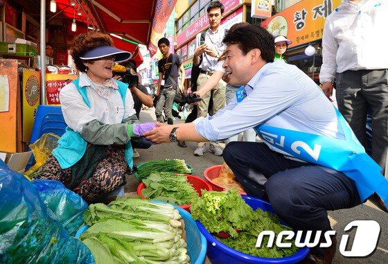 본문 이미지 - 서울 동작을에 출마한 기동민 새정치민주연합 후보가 13일 오후 서울 동작구 남성시장을 방문해 지역 주민과 인사를 나누고 있다. 2014.7.13/뉴스1 © News1   송은석 기자