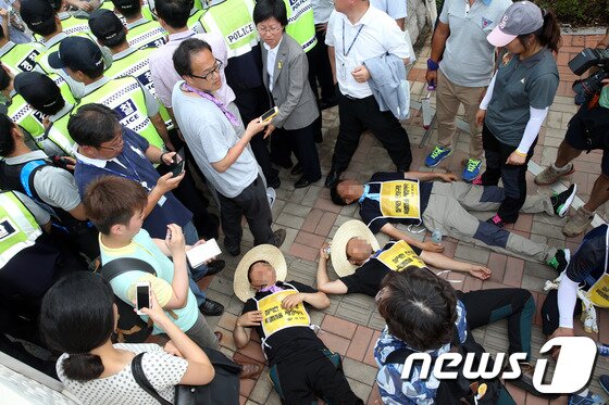 본문 이미지 - 1박2일 도보행진에 나선 세월호 침몰 사고 생존학생들이 국회에 도착한 16일 오후 세월호 유가족들이 국회 진입을 저지한 경찰들에게 항의하며 인도에 드러누워 있다. 2014.7.16/뉴스1 © News1   이광호 기자