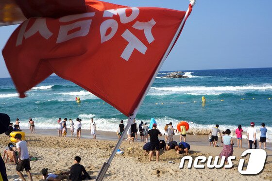 본문 이미지 - 27일 강원 강릉시 경포해변을 찾은 피서객들이 너울성 파도로 입수가 금지되어 바다에 들어가지 못하고 있다. 이날 강원 동해안 대부분의 해수욕장은 너울성 파도로 입수가 금지됐다. 이날 오전11시 기상청에서는 오후 해상 예보로 풍속 8~12m/s, 파고 1~2m가 일 것으로 발표했다. 2014.7.27/뉴스1