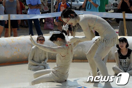 본문 이미지 - 27일 강원 동해시 망상해변에서 피서객들이 지역 천연광물인 화이트견운모를 이용한 축제를 즐기고 있다. 이곳에서는 내달 3일까지 망상해변축제가 진행되며 현재까지 50여 만명의 피서객이 방문했다. 2014.7.27/뉴스1