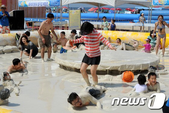 본문 이미지 - 27일 강원 동해시 망상해변에서 피서객들이 지역 천연광물인 화이트견운모를 이용한 축제를 즐기고 있다. 이곳에서는 내달 3일까지 망상해변축제가 진행되며 현재까지 50여 만명의 피서객이 방문했다. 2014.7.27/뉴스1