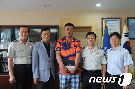 본문 이미지 - 28일 울산남부경찰서 유윤종 서장(오른쪽 두 번째)이 &acute;묻지마 살인사건&acute;의 피의자를 붙잡은 공로로 이대식(가운데)씨에게 감사장과 소정의 선물을 전달했다. (울산지방경찰청 제공) ⓒ News1