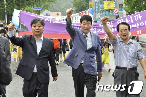 본문 이미지 - 3일 최문순 화천군수(왼쪽)와 정덕후 화천역 설치 범 군민대책위원장(가운데)이 화천역 설치를 위해 화천읍 일원을 돌며 결의를 다지고 있다.2014.7.3/뉴스1화천역 설치 범 군민대책위(위원장 정덕후)와 지역 사회단체 회원 300여명은 이날 화천관내 일원을 걸으며 동서고속화철도 화천역 설치 촉구결의 대회를 가졌다. © News1   홍성우 기자