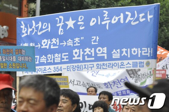 본문 이미지 - 3일 동서고속화철도 화천역 설치 촉구결의 대회가 화천군에서 열린 가운데 화천라이온스클럽 회원들이 화천역 설치를 주장하는 플랜카드를 들고 있다.2014.7.3/뉴스1최문순 화천군수와 화천역 설치 범 군민대책위(위원장 정덕후) 및 지역 사회단체 회원 300여명은 이날 화천관내 일원을 걸으며 동서고속화철도 화천역 설치 촉구결의 대회를 가졌다. © News1   홍성우 기자