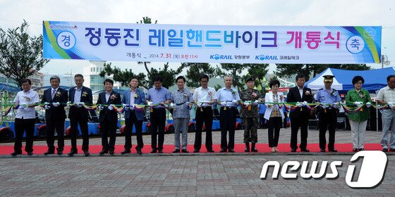본문 이미지 - 31일 강릉 정동진에 조성된 레일핸드바이크 개통식에 참가한 최명희 강릉시장을 비롯한 관계자들이 테이프 커팅식을 하고 있다. 정동진레일핸드바이크는 이날 개통식을 시작으로 8월부터 본격적인 운행에 들어간다. 2014.7.31/뉴스1