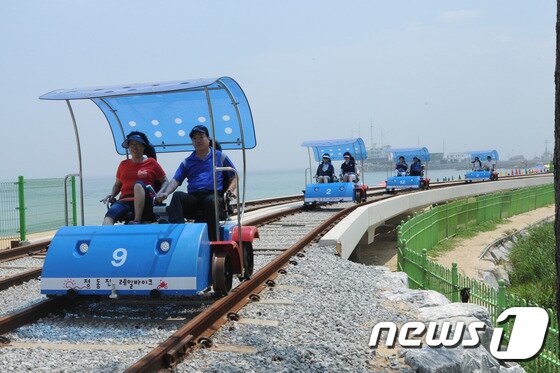 본문 이미지 - 31일 강릉 정동진에 조성된 레일핸드바이크 개통식에 참가한 시민들이 시승식을 하며 즐거워하고 있다. 정동진레일핸드바이크는 이날 개통식을 시작으로 8월부터 본격적인 운행에 들어간다. 2014.7.31/뉴스1