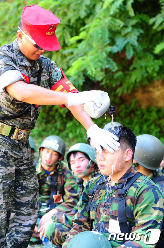 (포항=뉴스1) 최창호 = 31일 오전 경북 포항 해병대 1사단 유격장에서 열린 여름 해병대 캠프에 참가한 학생들에게  교관이 수통의 물을 부어주고 있다. 해병대 1사단이 운영하는 …