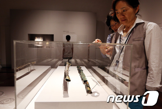 (서울=뉴스1) 허경 기자 = 8일 오후 서울 용산구 국립중앙박물관에서 열린 '금관총과 이사지왕' 테마전에서 관람객들이 아사지왕의 고리자루 큰 칼을 보고 있다.오는 9월 28일까지 …
