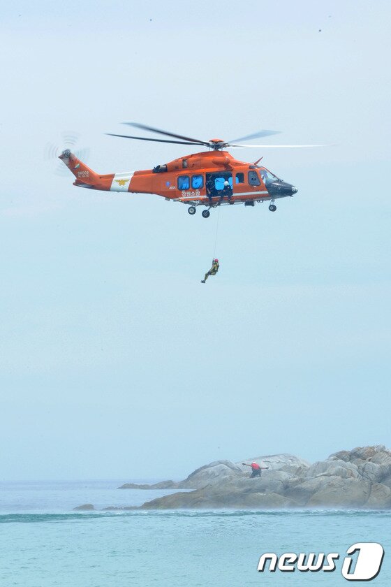 본문 이미지 - 9일 오전 강릉 경포해변에서 열린 '2014 전국 119시민수상구조대 발대식'에서 해경 구조헬기가 섬에 고립된 조난자를 구하는 구조시범을 펼치고 있다.이날 발대식에는 중앙119구조단본부, 강원소방본부, 동해해양지방경찰청 소속 최정예 수난구조대의 다수 익수자 인명구조 시범훈련도 함께 펼쳐졌다. 2014.7.9/뉴스1 © News1 서근영 기자