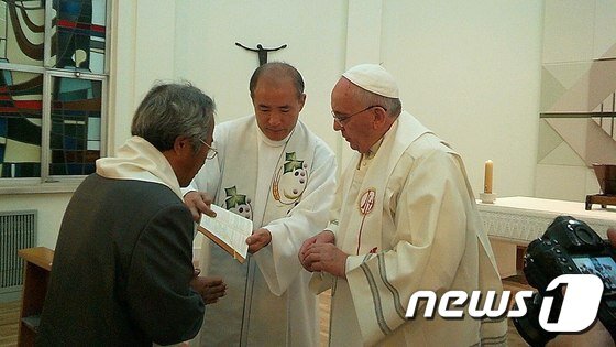 본문 이미지 - 프란치스코 교황이 17일 오전 서울 종로구 주한 교황청대사관에서 세월호 참사 희생자인 단원고등학교 이승현 군의 아버지 이호진씨에게 세례성사를 하고 있다. 이 씨의 세례명은 교황과 같은 '프란치스코'로 정해졌다. (이호진씨 페이스북) 2014.8.17/뉴스1