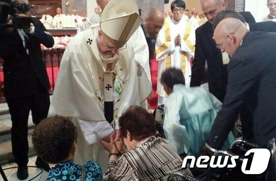 본문 이미지 - 서울 명동대성당에서 열린 '화해와 평화를 위한 미사'에 참석한 위안부 피해자 할머니들을 위로하고 있는 프란치스코 교황.(나눔의집 제공)/ⓒ News1