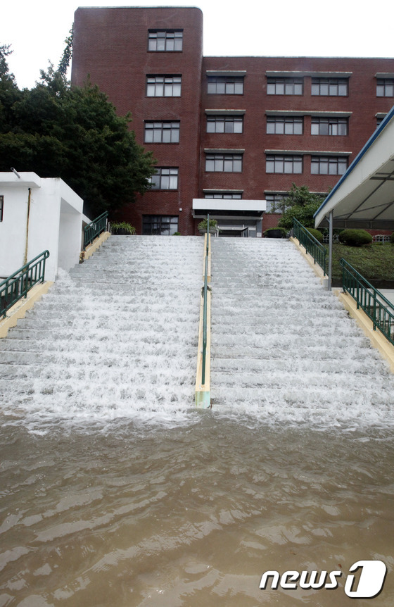 (부산=뉴스1) 여주연 기자 = 25일 오후 부산에 내린 집중호우로 인해 부산 북구 구포동에 위치한 양덕여중 계단으로 산에서 흘러내린 빗물이 넘치고 있다. 2014.8.25/뉴스1 …