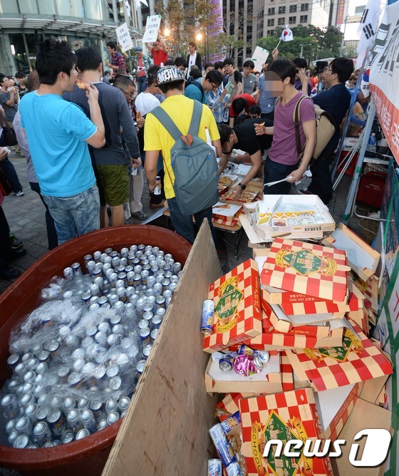 (서울=뉴스1) 손형주 기자 = 일간베스트저장소(이하 일베) 회원들과 자유청년연합 회원들이 13일 오후 광화문 단식농성장 인근인 동아일보 사옥 앞에서 치킨과 피자를 먹는 '폭식 퍼 …