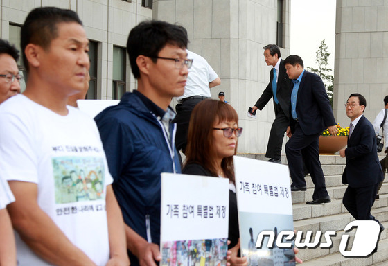 세월호 가족대책위 뒤로 국회 들어서는 김무성 대표
