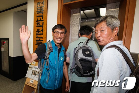 본문 이미지 - 서울고법이 전국교직원노동조합(전교조)에 대한 법외노조 효력을 정지하는 결정을 내린 19일 김정훈 전교조 위원장이 밝은 표정으로 서울 서대문구 전교조 본부 사무실을 나서고 있다. 이날 오전 서울 고법은 "법외노조 통보 처분의 효력을 정지해달라＂며 전교조가 제기한 집행정지 신청을 받아들였다. 재판부는 ＂교원노조법 제2조는 헌법상 과잉금지원칙에서 벗어나 교원의 헌법상 보장된 단결권과 평등권을 침해하는 위헌적인 조항이라고 의심할 만한 상당한 이유가 있다＂며 효력 정지를 결정했다. 2014.9.19/뉴스1 ⓒ News1 유승관 기자