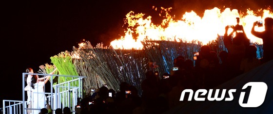 (인천=뉴스1) 양동욱 기자 = 2014 인천아시아경기대회 개막일인 19일 오후 인천아시아드주경기장에서 열린 개회식에서 배우 이영애가 성화를 점화하고 있다. 2014.9.19/뉴스 …