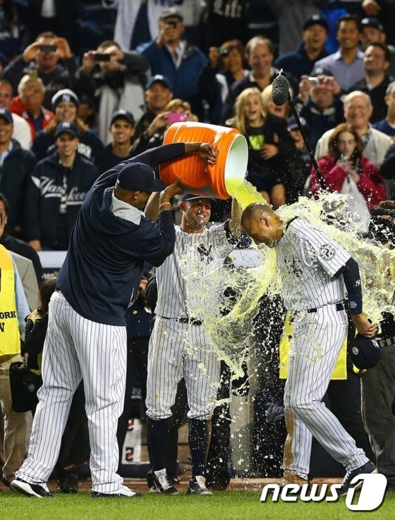 본문 이미지 - 뉴욕 양키스의 동료들이 끝내기 안타를 친 데릭 지터(오른쪽)에게 스포츠 음료를 뿌리고 있다 뿌리는 선수들의 얼굴에도, 음료 세례를 받는 데릭 지터의 얼굴에도 미소가 가득하다. 관람석에 앉아있는 팬들도 함박웃음을 짓고 있다. ⓒ AFP=News1