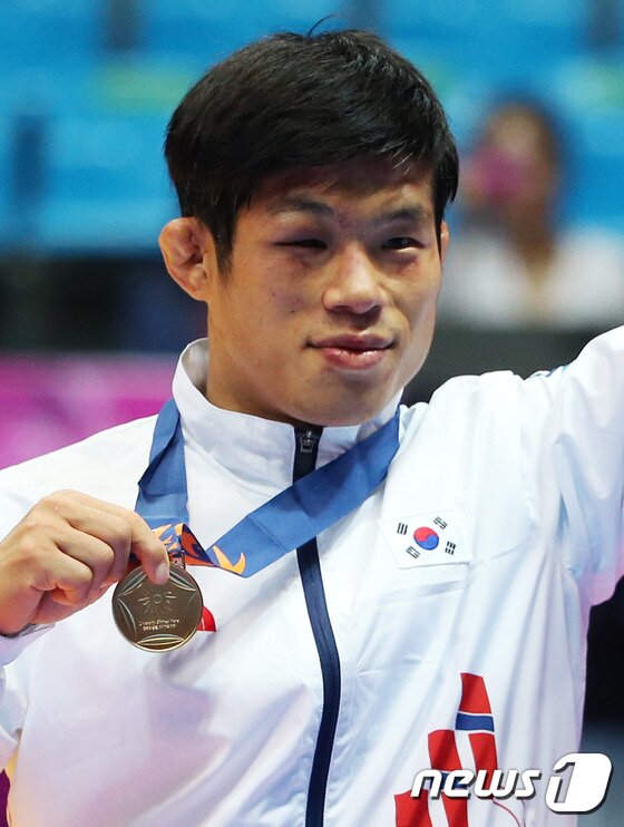 본문 이미지 - 한국 정지현이 30일 인천 도원체육관에서 열린 '2014 아시안게임' 레슬링 그레코로만형 71kg급 결승전 시상식에서 금메달을 받고 메달을 번쩍 들고 있다. ⓒ News1 송원영 기자