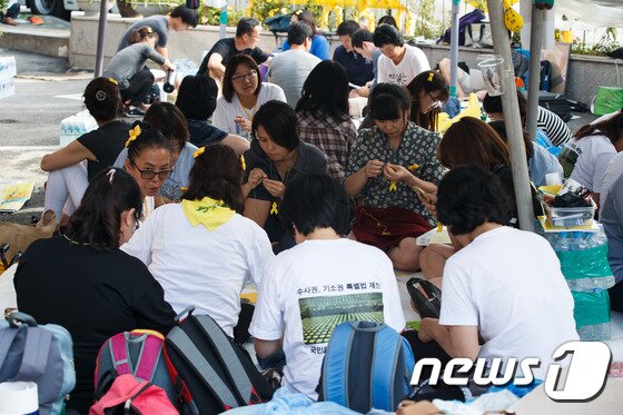 본문 이미지 - 민족대명절 추석 연휴를 하루 앞둔 5일 오후 서울 청운·효자동주민센터 앞에서 세월호 참사 유가족들이 수사권·기소권이 포함된 특별법 제정을 촉구하며 15일째 이어진 농성 중 노란리본을 만들고 있다. 2014.9.5/뉴스1 2014.09.05/뉴스1 ⓒ News1 유승관 기자