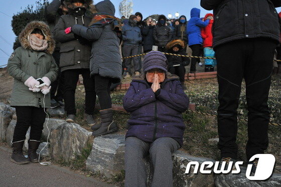 본문 이미지 - 1일 오전 울산 울주군 간절곶에서 한 해맞이객이 일출을 보며 소원을 빌고 있다.간절곶 일출은 오전 7시 31분 22초 시작돼 한반도에서 가장 빨랐다. ⓒ News1 조창훈 기자
