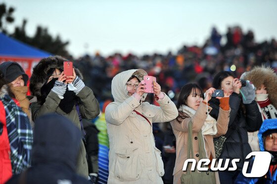 본문 이미지 - 1일 오전 울산 울주군 간절곶에서 한 해맞이객이 핸드폰으로 일출을 찍고 있다. 간절곶 일출은 오전 7시 31분 22초 시작돼 한반도에서 가장 빨랐다. ⓒ News1 조창훈 기자 