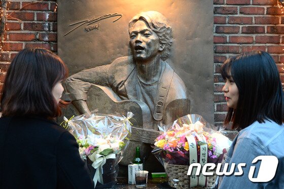 본문 이미지 - 가수 故 김광석의 19주기를 맞은 6일 오후 서울 종로구 동숭동 학전블루소극장에 세워진 고인의 노래비에 추모 꽃다발이 놓여 있다. 2015.1.6/뉴스1 ⓒ News1 민경석 기자
