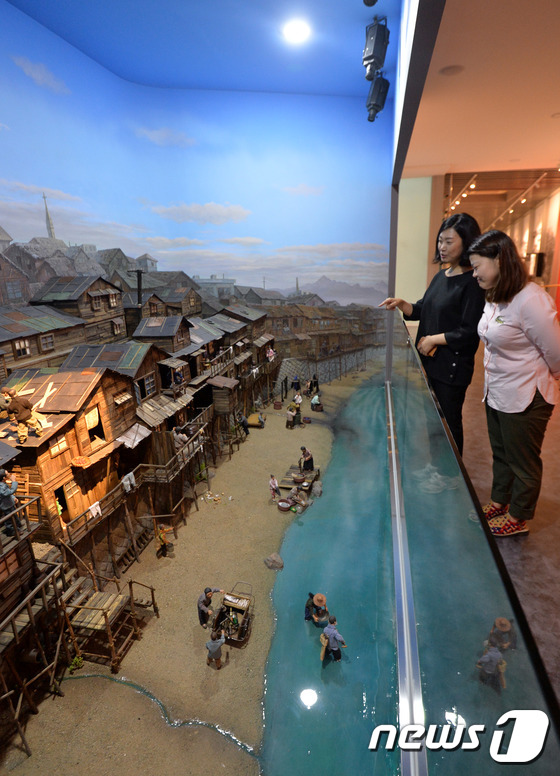 (서울=뉴스1) 박세연 기자 = 1일 오후 서울 성동구 청계천박물관을 찾은 관람객들이 1920년대 청계천 판자촌 모습을 재현한 모형을 바라보고 있다.청계천박물관은 상설전시실을 전면 …