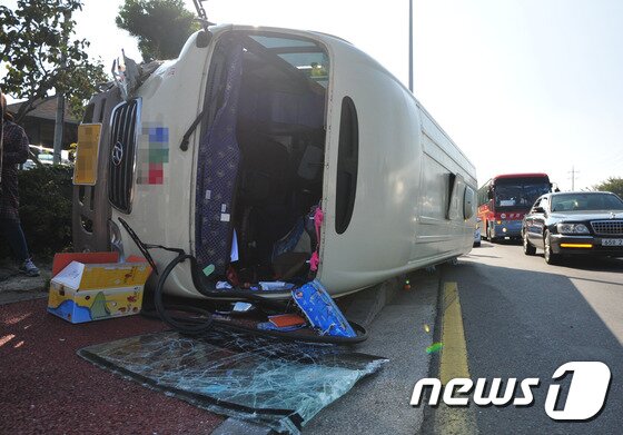 본문 이미지 - 18일 오후 제주시 무수천주유소 앞 도로에 25인승 버스가 옆으로 쓰러져 있다. 이 사고로 버스에 타고 있던 13명 중 7명이 119에 의해 인근 병원으로 옮겨져 치료를 받고 있다. 경찰은 정확한 사고 경위를 조사 중이다. 2015.10.18./뉴스1 ⓒ News1 이석형 기자