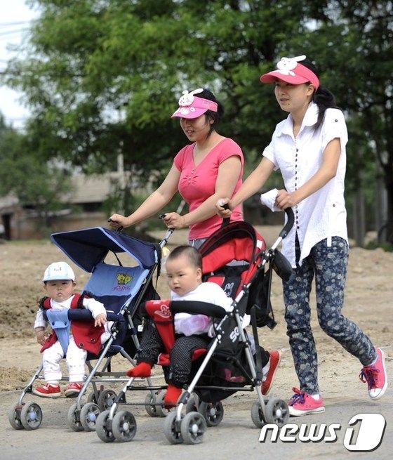 각각 1자녀만을 데리고 이동 중인 중국인 부모들.© AFP=뉴스1