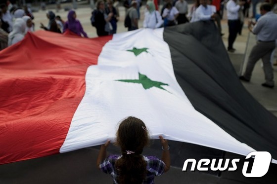 튀니지 '재스민 혁명'에 참여한 한 소녀가 튀니지 국기를 흔들고 있다.© AFP=뉴스1