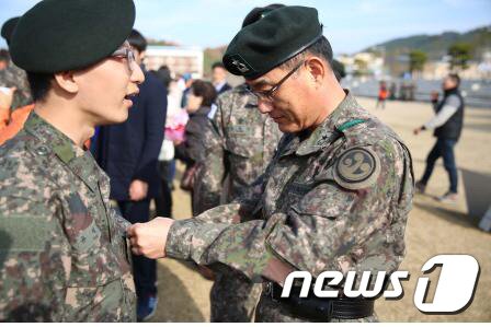 본문 이미지 - 문병호 39사단장이 신병교육을 마친 장병에게 계급장을 달아주고 있다.(39사단 제공) ⓒ News1 이철우 기자