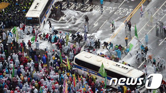 지난 14일 오후 서울 세종대로에서 열린 민중총궐기대회에서 참가자들이 경찰버스를 끌어내고 있다. /뉴스1 © News1 김명섭 기자
