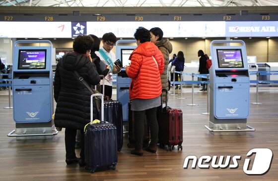 본문 이미지 - 겨울이 성큼 다가온 25일 두툼한 차림의 해외여행자들이 자동 탑승수속 서비스에 대한 안내를 받고 있다.  2015.11.25. 뉴스1트래블 ⓒ News1travel 조용식 기자